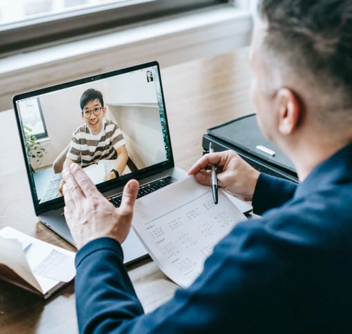 Masculine presenting people in a one on one meeting via laptop